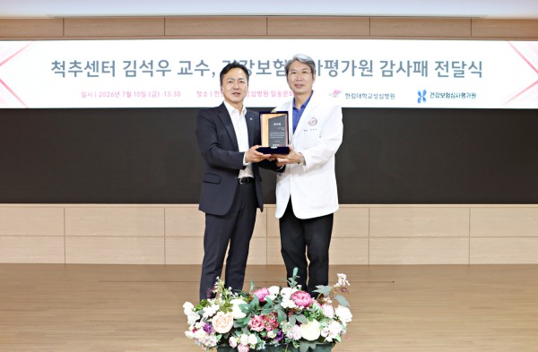 [사진] 김석우 한림대학교성심병원 척추센터 교수(오른쪽)가 감사패를 전달받으며 김기원 건강보험심사평가원 경기남부본부장(왼쪽)과 함께 기념 촬영을 하고 있다