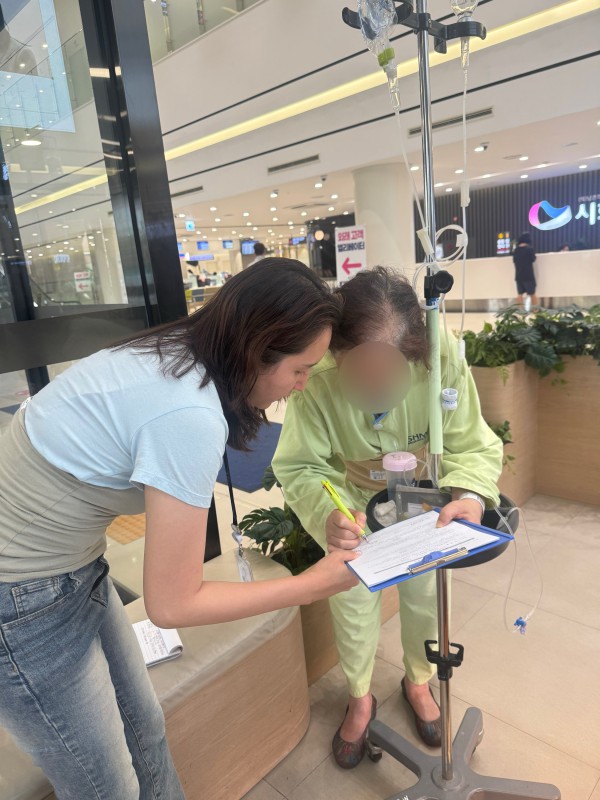 [사진] 정왕4동 행정복지센터 관계자가 입원 환자에게 의료 및 요양돌봄 서비스를 안내하고 있다