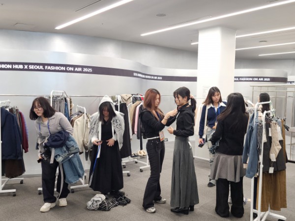 패션디자인서포터즈 대학생 멘토들이 동대문디자인플라자(DDP) 쇼룸 샘플스토어에서 청소년 참가자들의 조별 콘셉트에 맞춰 의상 선택과 스타일링을 도와주며 룩북 촬영 체험을 하고 있다