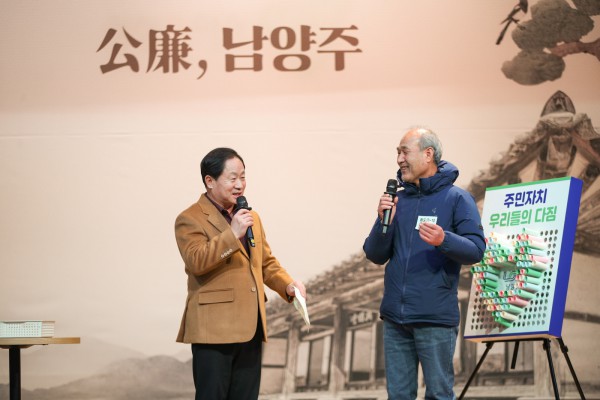 주광덕 시장과 주민자치회 위원이 다짐종이를 함께 나누고 있다.