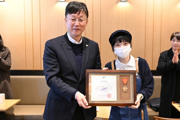 이민근 안산시장(왼쪽)이 지난달 수어로 고객에게 감동 전해 지역 사회에 선한 영향력을 끼친 커피점 점주에게 모범시민 표창을 수여하고 함께 기념촬영을 하고 있다.