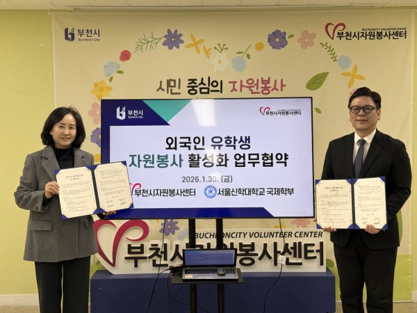 김세화 자원봉사센터장과 김성호 서울신학대학교 국제학부장이 협약 체결 기념 촬영을 하고 있다.
